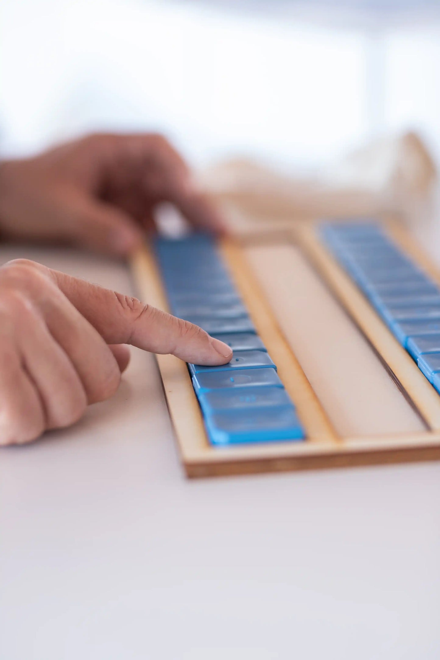 Person touching BR'EYE dominoes - Adapted school learning device